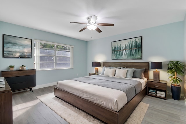 bedroom with ceiling fan and light hardwood / wood-style flooring