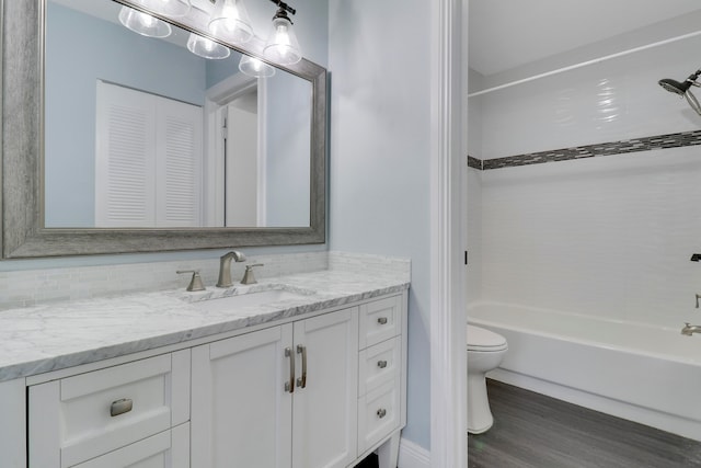 full bathroom featuring hardwood / wood-style flooring, vanity, toilet, and washtub / shower combination