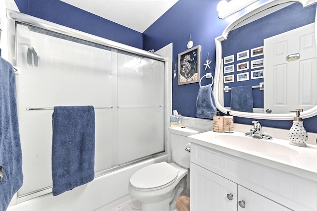 full bathroom with enclosed tub / shower combo, vanity, and toilet