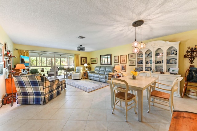 dining room featuring light tile patterned flooring and a textured ceiling