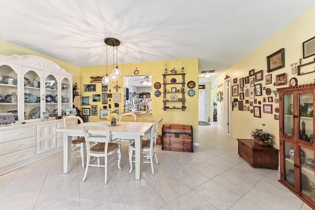 tiled dining room with a textured ceiling