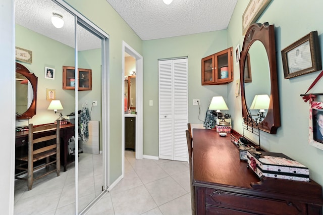 office area with a textured ceiling and light tile patterned floors