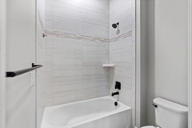 bathroom with toilet and tiled shower / bath combo