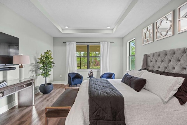 bedroom with a tray ceiling and hardwood / wood-style floors