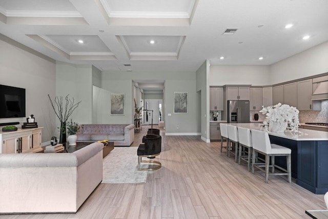 living room with beam ceiling, ornamental molding, light hardwood / wood-style flooring, and coffered ceiling