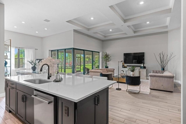 kitchen with sink, coffered ceiling, a kitchen island with sink, stainless steel dishwasher, and light wood-type flooring