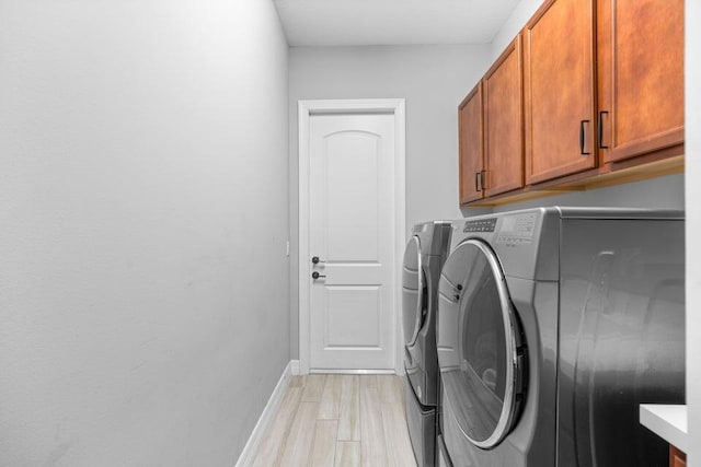 laundry area with cabinets, light wood-type flooring, and independent washer and dryer