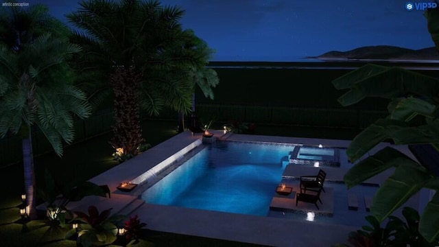 pool at night with an in ground hot tub