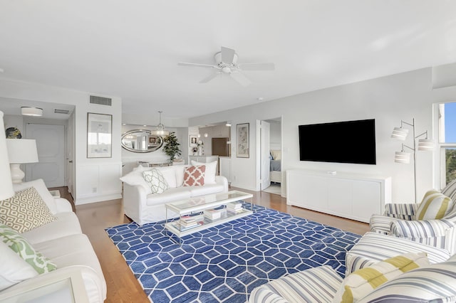 living room featuring hardwood / wood-style floors and ceiling fan