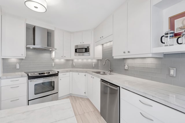 kitchen featuring sink, white cabinets, wall chimney range hood, and appliances with stainless steel finishes