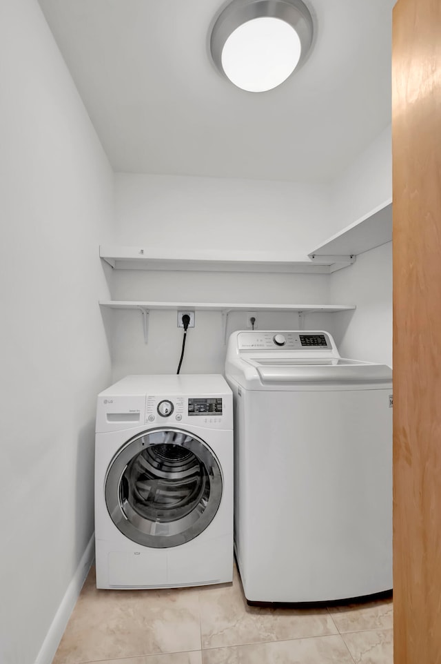 laundry room featuring separate washer and dryer and light tile patterned floors