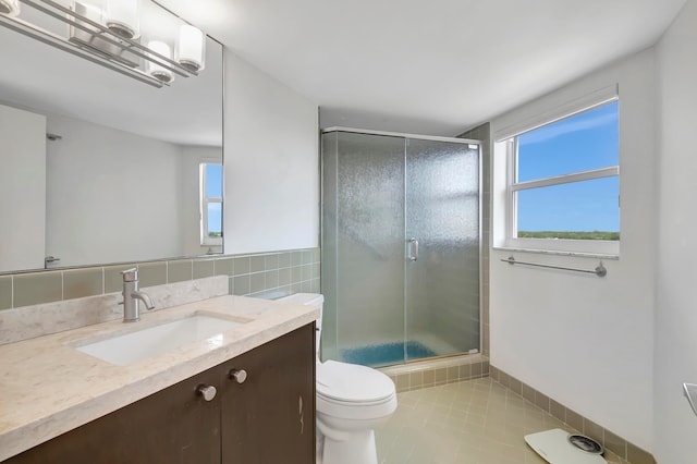 bathroom with tile patterned floors, vanity, toilet, and a shower with door