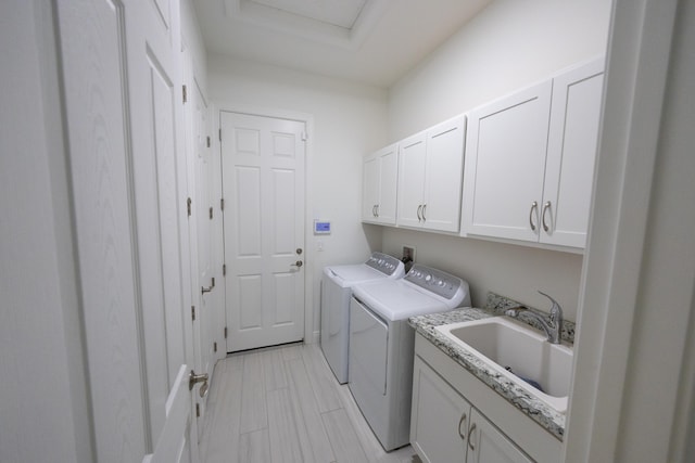 washroom with sink, cabinets, and independent washer and dryer