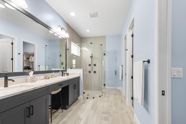 bathroom with walk in shower, hardwood / wood-style floors, and vanity