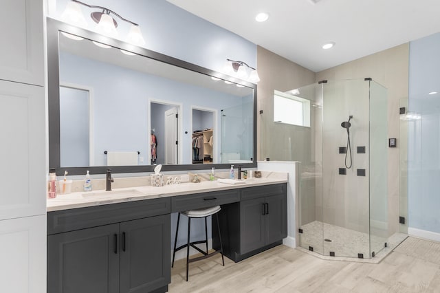 bathroom featuring vanity, hardwood / wood-style flooring, and a shower with door