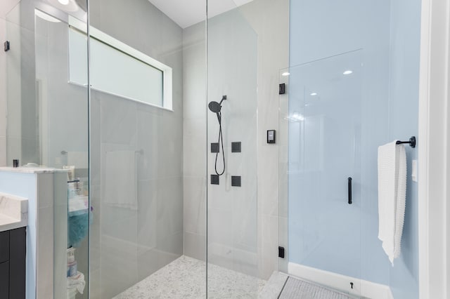 bathroom featuring vanity and a shower with door