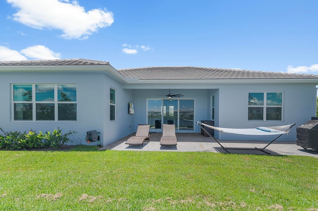 back of property featuring a patio area, a lawn, and ceiling fan