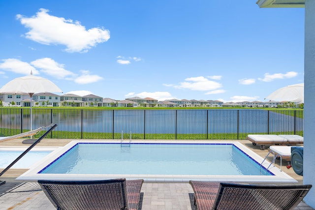 view of swimming pool with a water view and a patio area