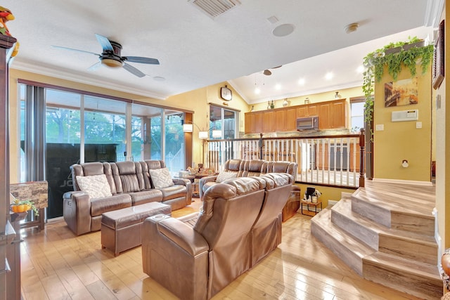 living room featuring ceiling fan, crown molding, light hardwood / wood-style floors, vaulted ceiling, and a textured ceiling