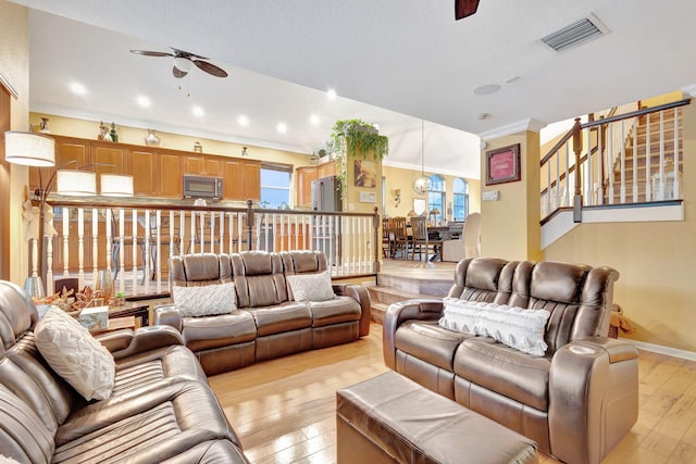 living room with ceiling fan, light hardwood / wood-style floors, and ornamental molding