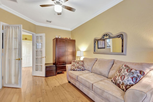 living room featuring ceiling fan, light hardwood / wood-style floors, and crown molding