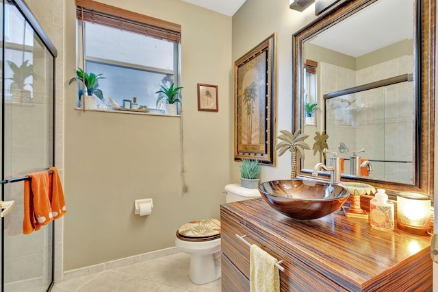 bathroom featuring tile patterned flooring, a healthy amount of sunlight, toilet, and a shower with door