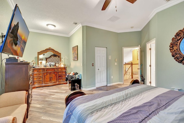 bedroom with a textured ceiling, light hardwood / wood-style flooring, ceiling fan, and ornamental molding