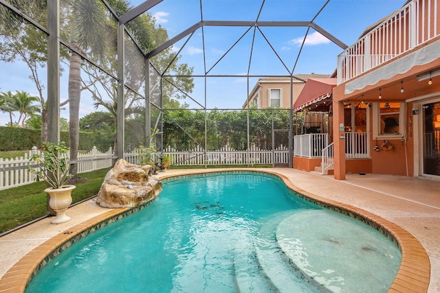 view of pool featuring glass enclosure and a patio area