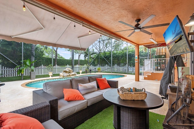 exterior space with outdoor lounge area, ceiling fan, a fenced in pool, and a lanai