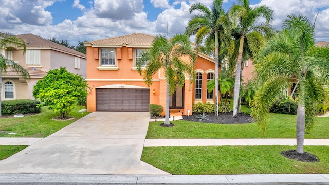 mediterranean / spanish house featuring a garage and a front yard