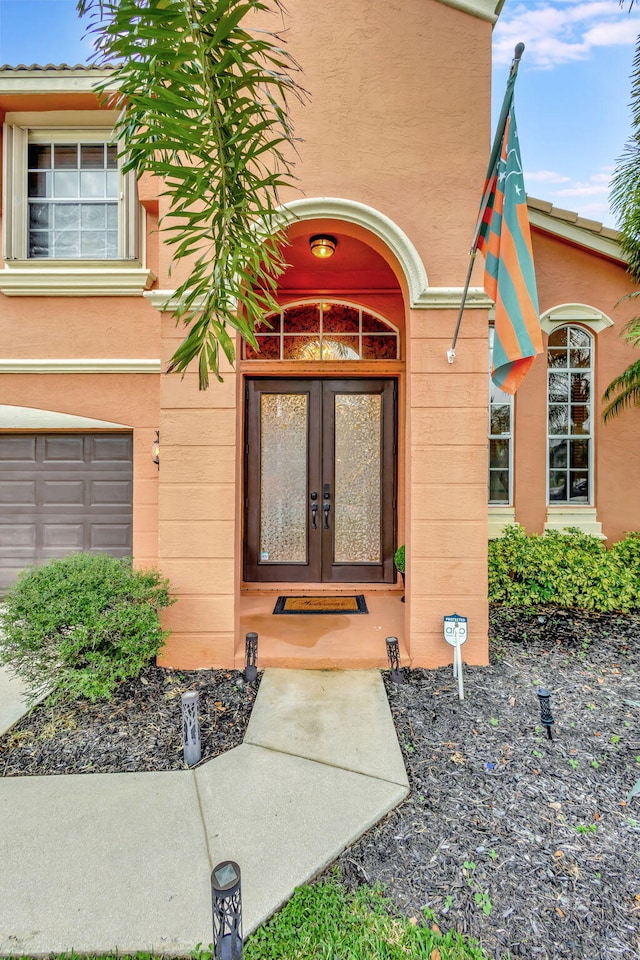 entrance to property with a garage and french doors