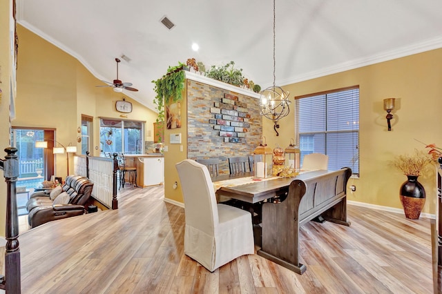 dining area with crown molding, high vaulted ceiling, light hardwood / wood-style floors, and ceiling fan with notable chandelier