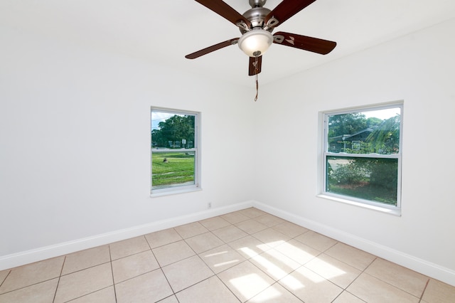 tiled empty room with a wealth of natural light and ceiling fan