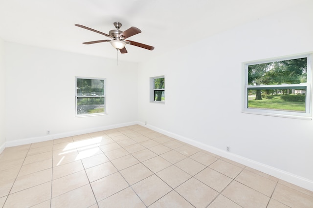 tiled empty room featuring a wealth of natural light and ceiling fan