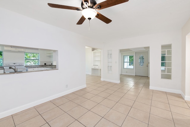 tiled spare room featuring built in shelves, ceiling fan, and sink