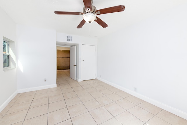 spare room with ceiling fan and light tile patterned floors