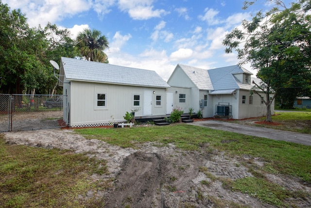 back of house with central AC and a yard