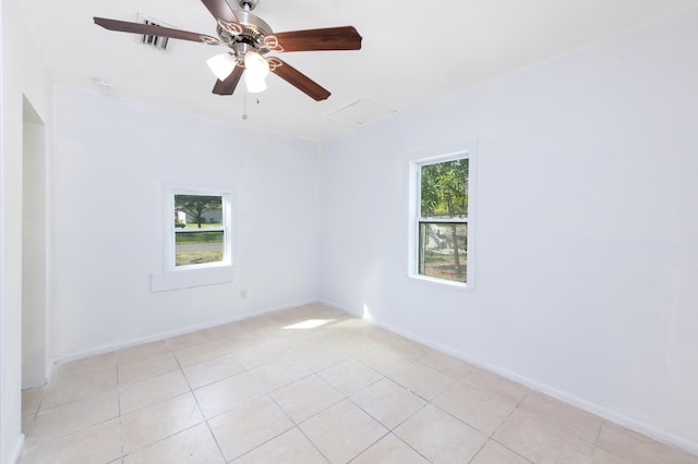 tiled spare room with ceiling fan and plenty of natural light