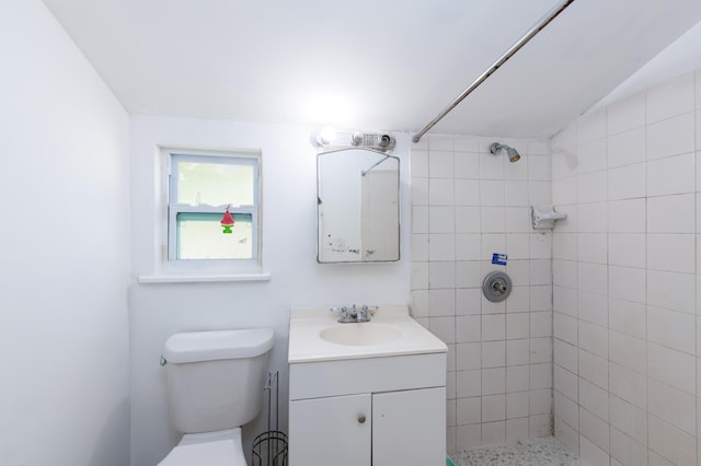 bathroom with toilet, vanity, vaulted ceiling, and tiled shower