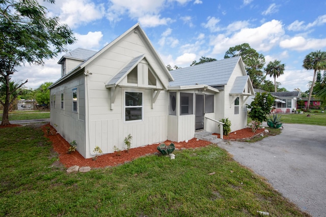 view of front of property featuring a front yard and a sunroom