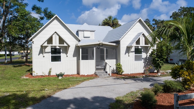 view of front of property with a front lawn and a sunroom