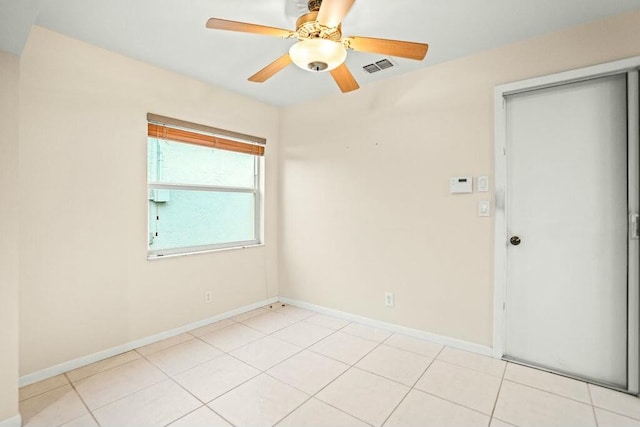 tiled spare room with ceiling fan