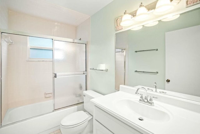 full bathroom with combined bath / shower with glass door, vanity, toilet, and tile patterned flooring