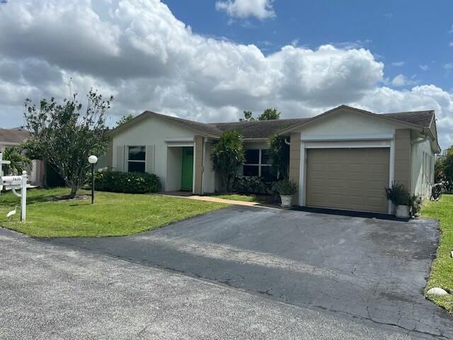 7410 Pine Forest Cir W, Lake Worth, FL 33467 - single story home with an attached garage, driveway, stucco siding, and a front yard