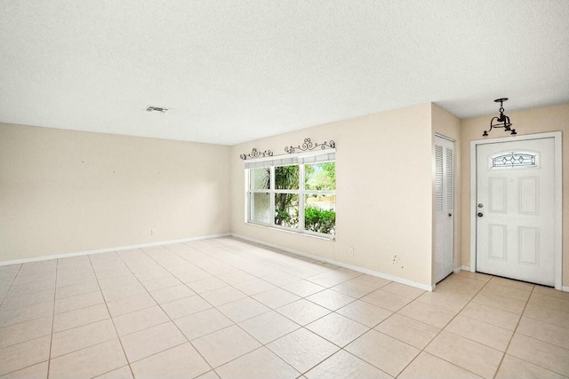 7410 Pine Forest Cir W, Lake Worth, FL 33467 - entryway with baseboards, a textured ceiling, light tile patterned floors, and visible vents