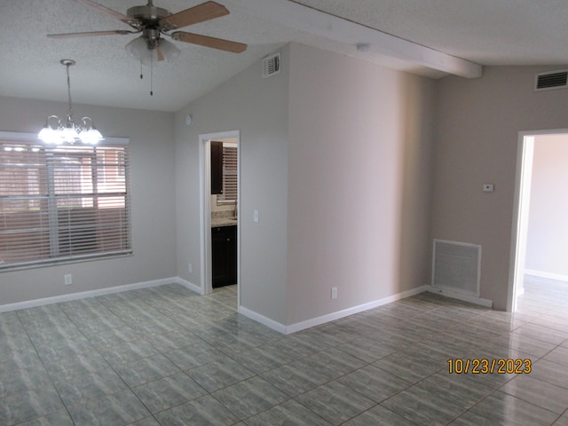 empty room with lofted ceiling with beams, a textured ceiling, and ceiling fan with notable chandelier