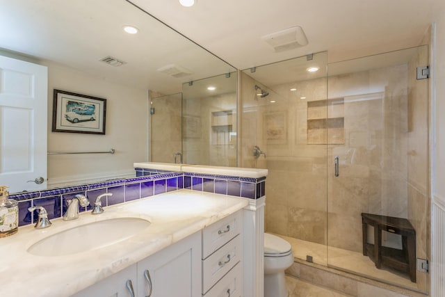 bathroom with vanity, toilet, walk in shower, and tasteful backsplash