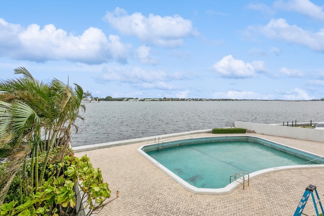 view of swimming pool featuring a patio area and a water view