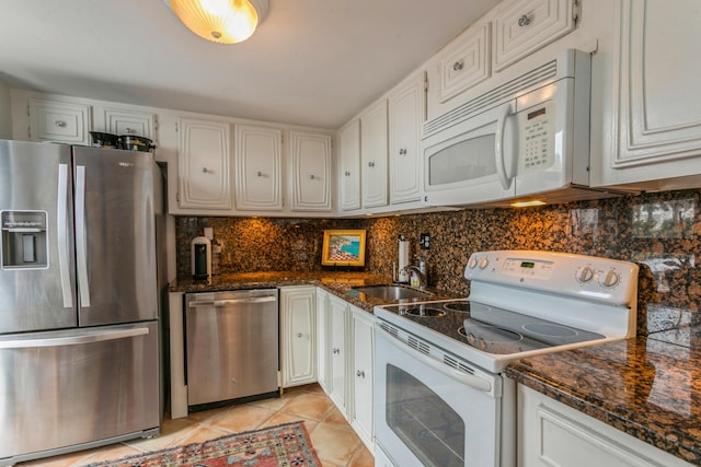 kitchen featuring sink, white cabinets, light tile patterned flooring, and appliances with stainless steel finishes