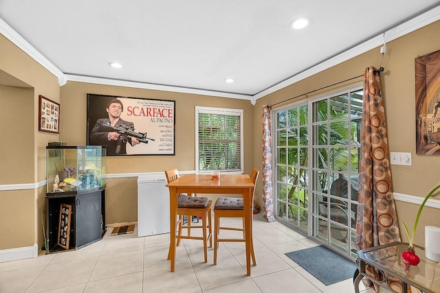 dining area with light tile patterned flooring and crown molding